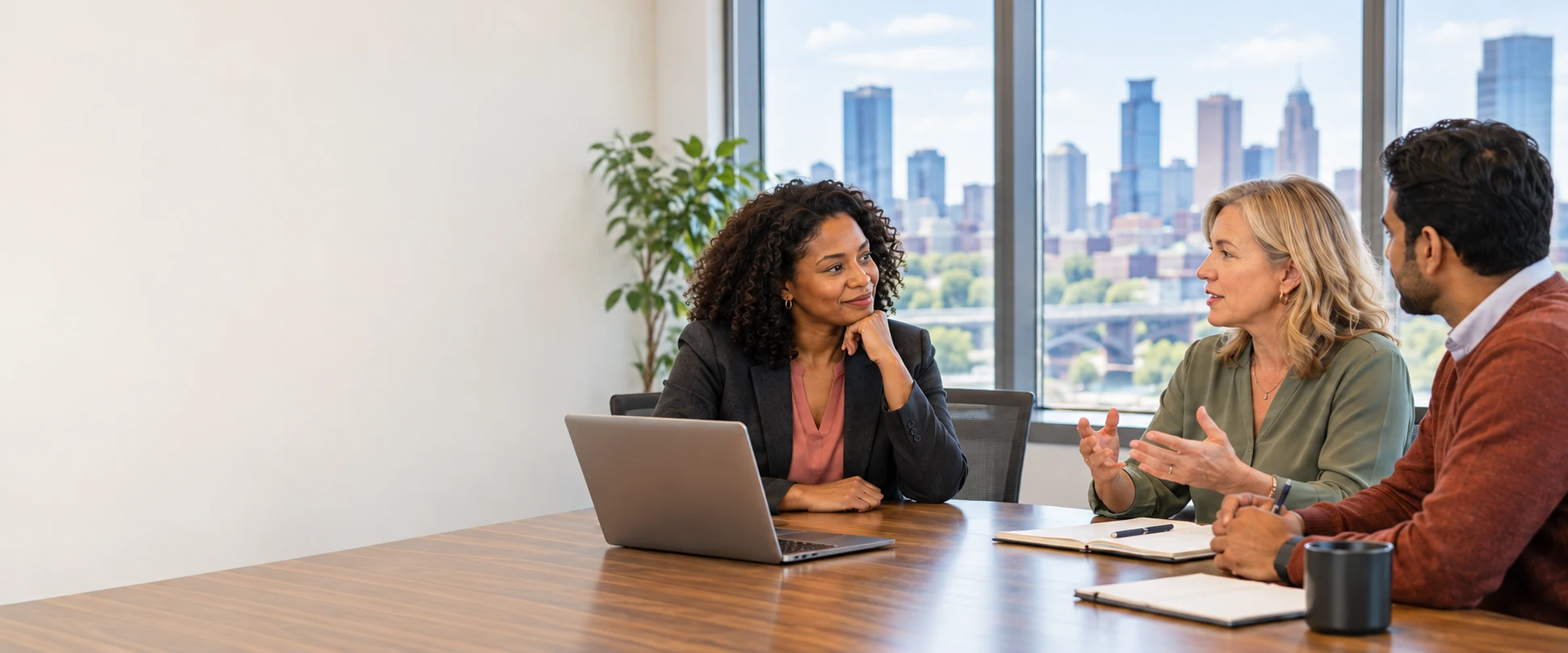 A technology consultant listening to a business owner and operations manager during a face-to-face consultation